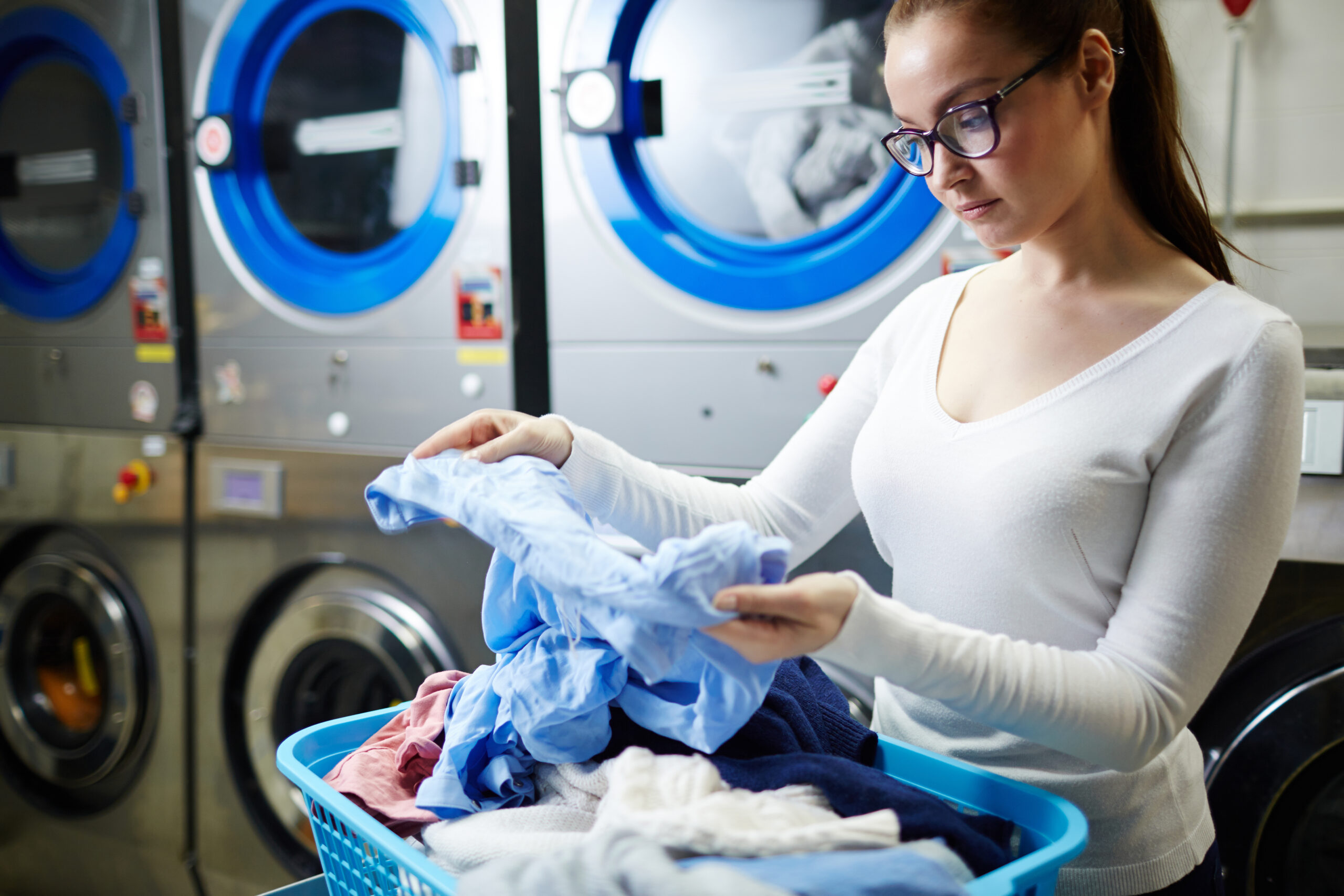 Woman looking at dirty shirt in laundry
